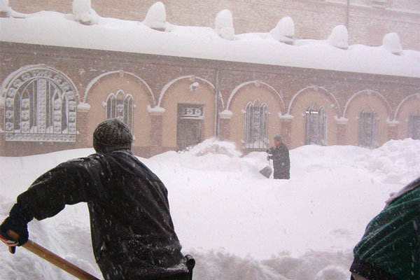 修道士たちと雪かきをするナルディ博士